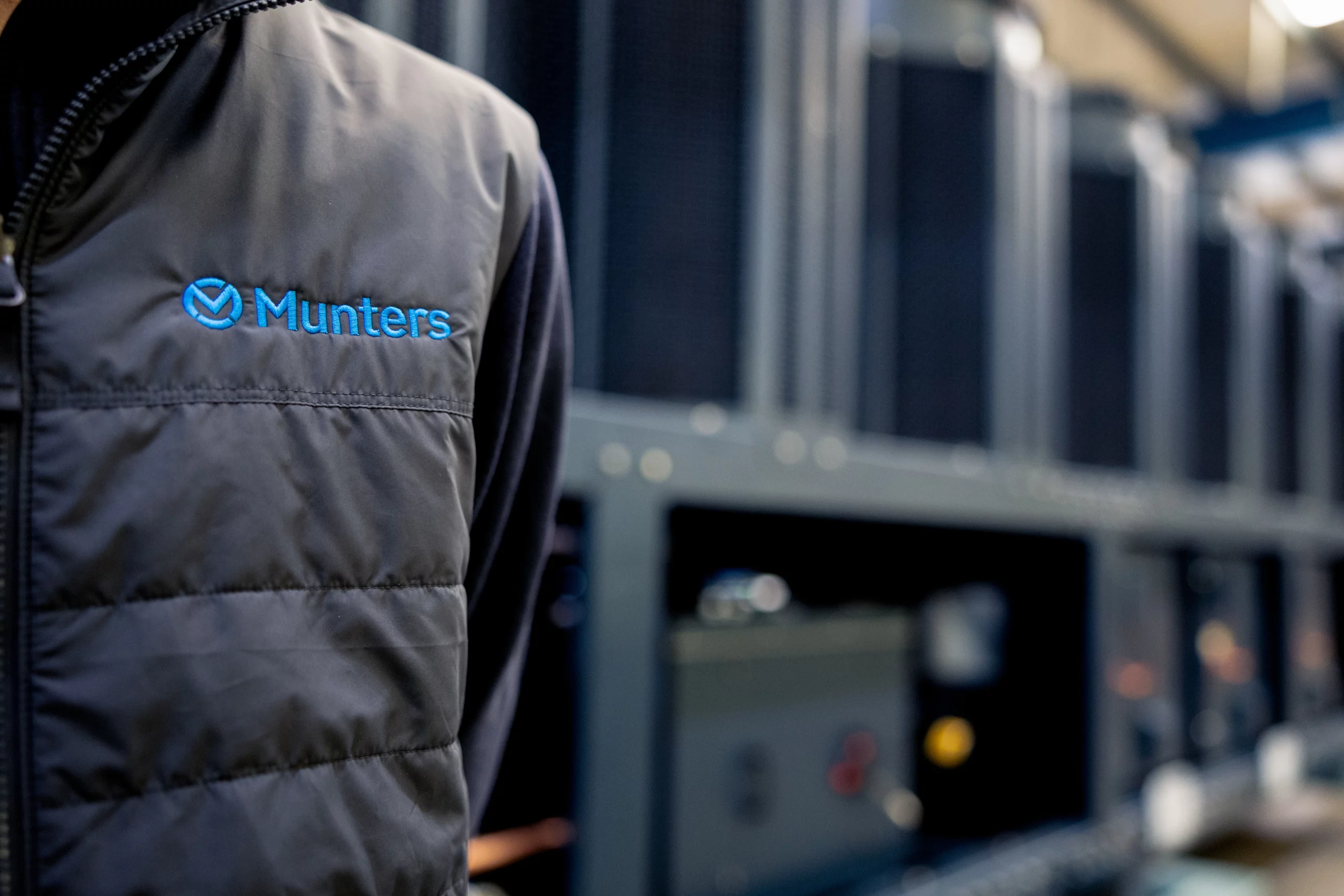 Person wearing a vest with Munters' logo in a data center environement.