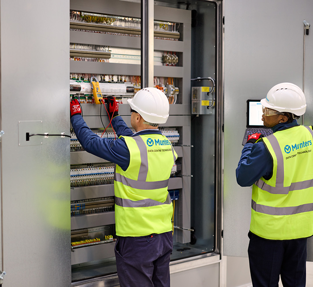 Two engineers in high-visibility vests in a Munters manufacturing facility.
