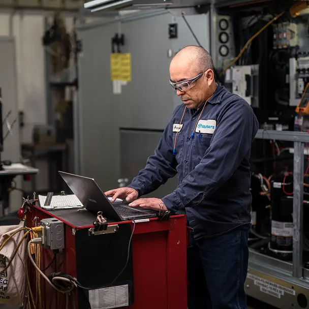 Man in Munters' warehouse working by a computer.